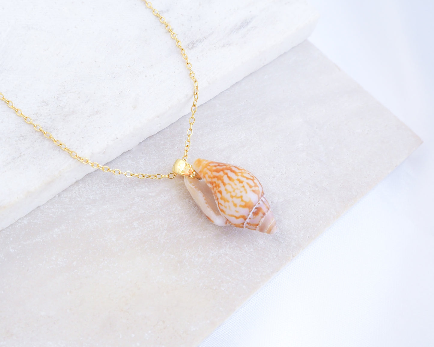 Close up of backside Rustic Dove Shell Gold Necklace on display, Detailed view of the Rustic Dove pendant, showcasing its natural patterns and coastal elegance. Sea By Lou