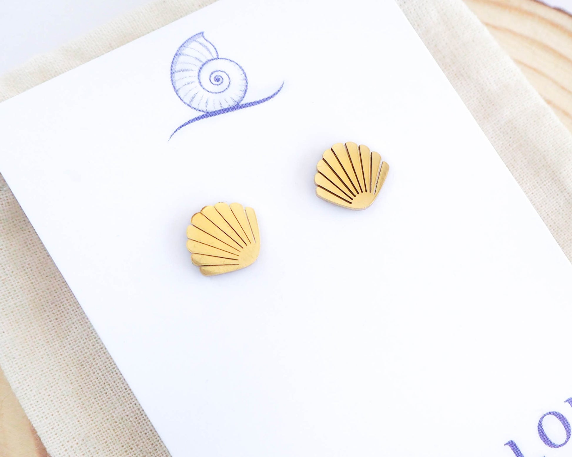 Close-up of Gold Shell Stud Earrings on white background: Coastal-inspired Jewelry