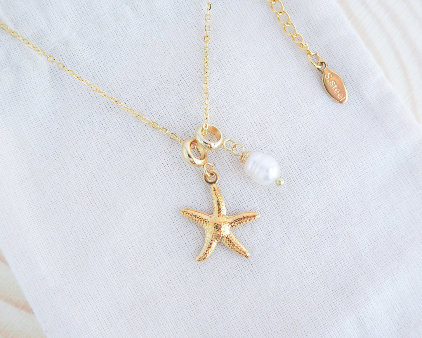 Gold Sea Star Starfish Necklace with Freshwater Pearl Bead on display