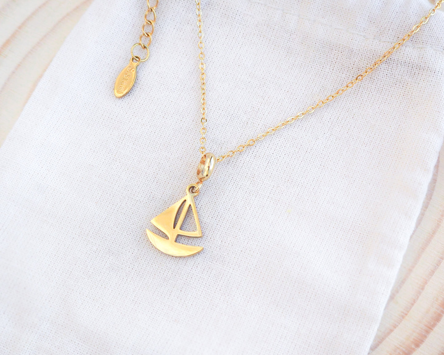 Gold Sailing Boat Necklace on display