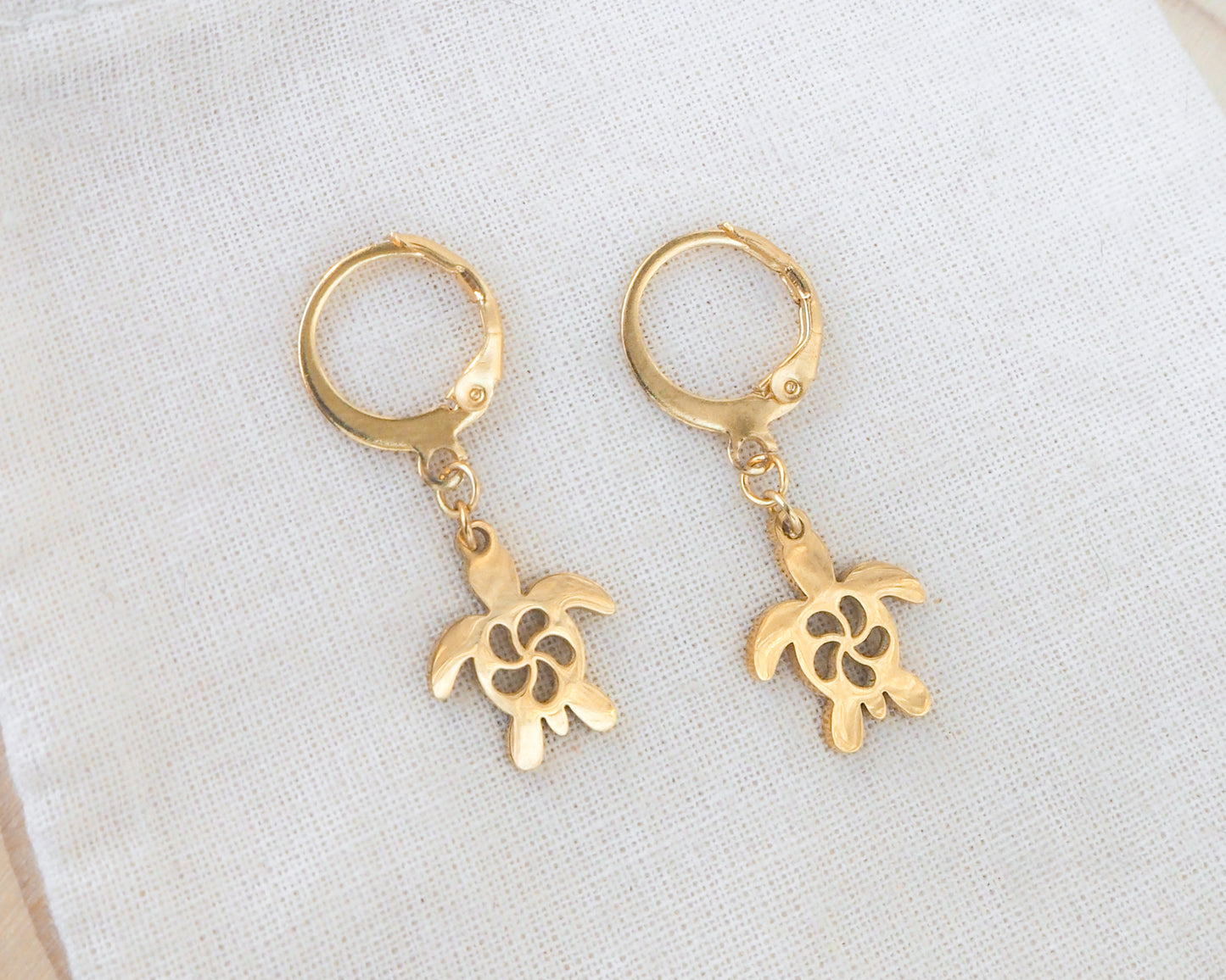 Gold Turtle Hoop Earrings on display