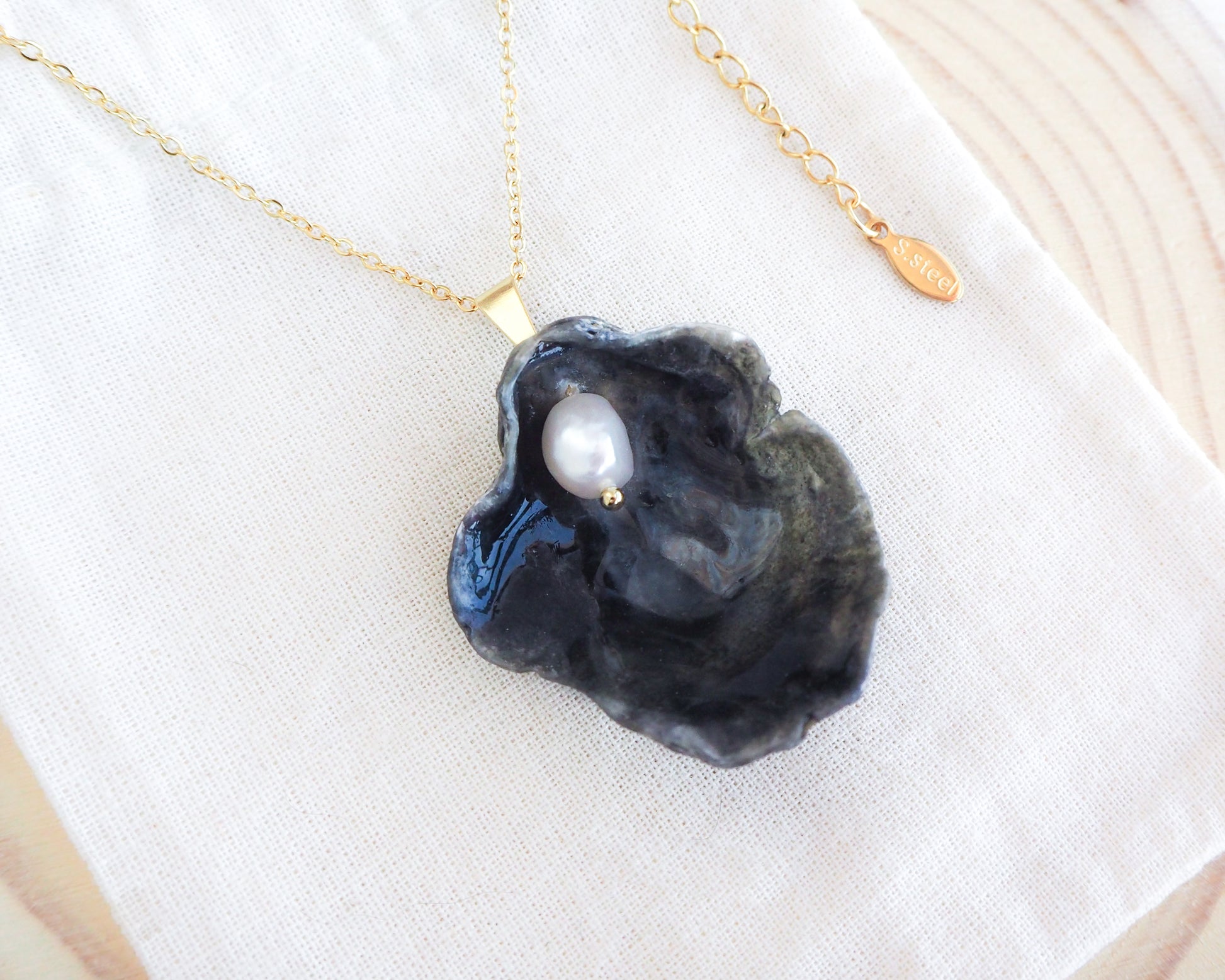 Gold Black Jingle Shell Necklace on display, Dark Mother of Pearl Pendant