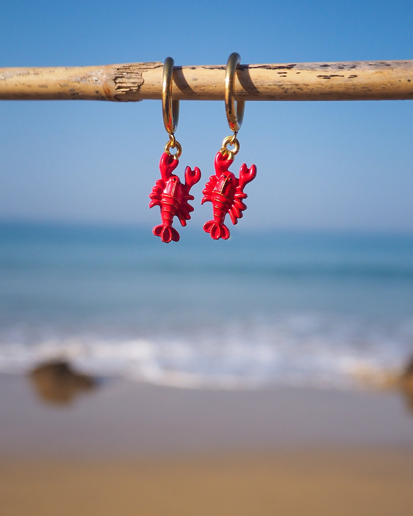 Red Lobster Gold Earrings with ocean background