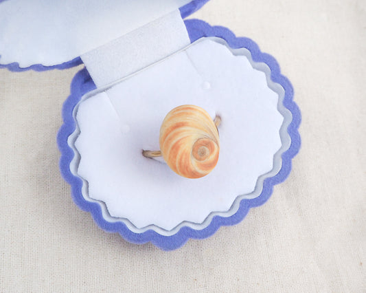 Ring on a shell-shaped jewelry display with a white background. Close up of Orange Yellow Eye of Saint Lucia Shell Gold Ring in velvet seashell box, Handcrafted Orange Shiva Eye Ring, Real Shiva Eye from Portugal, Handpicked eye of saint lucia, gold stainless steel ring, unique beach gift for ocean lovers