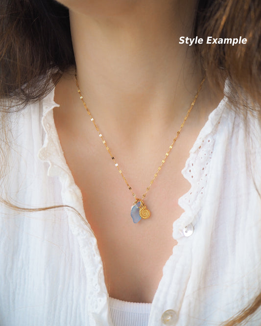 Model wearing Oceanic Trio Nautilus Blue Sea Glass Pearl Necklace on neck, nautilus shell necklace, ocean blue necklace, coastal jewelry, freshwater pearl necklace, gold seashell necklace, ocean-inspired jewelry, beach necklace, ocean treasure necklace