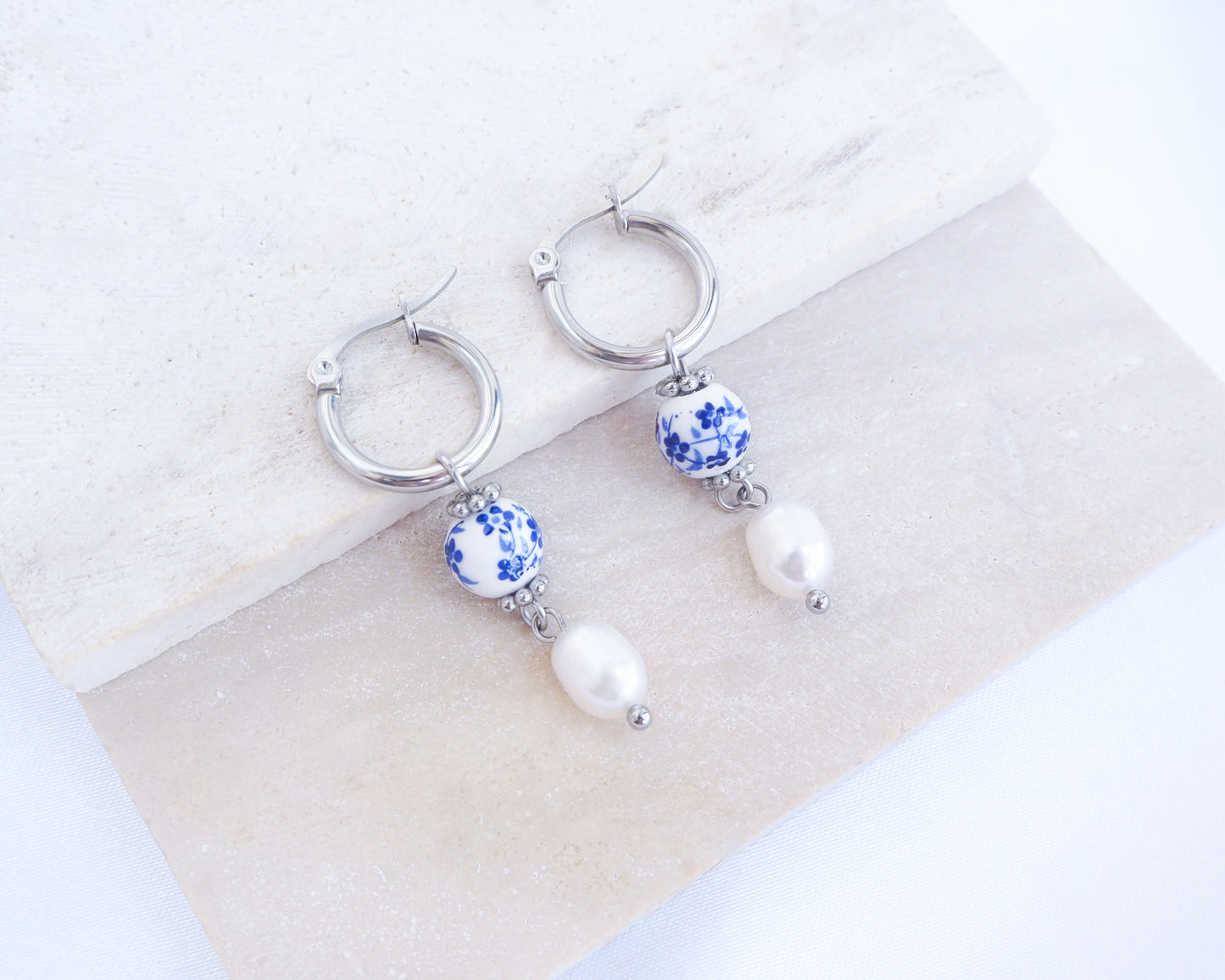 Front view of Silver Azulejo Pearl Earrings from Portugal on stone displayed, Lisbon Tile Jewelry, Portuguese memory holiday gift.