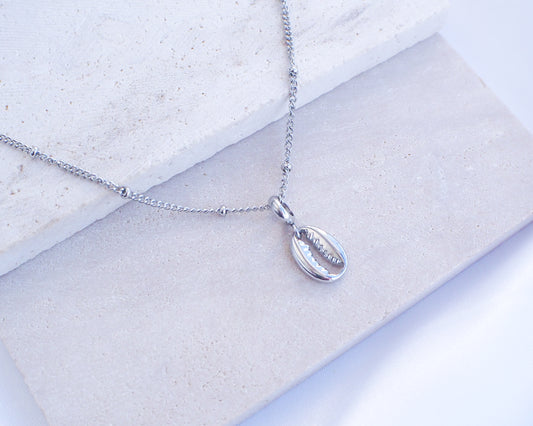 Silver Cowrie Necklace on stone