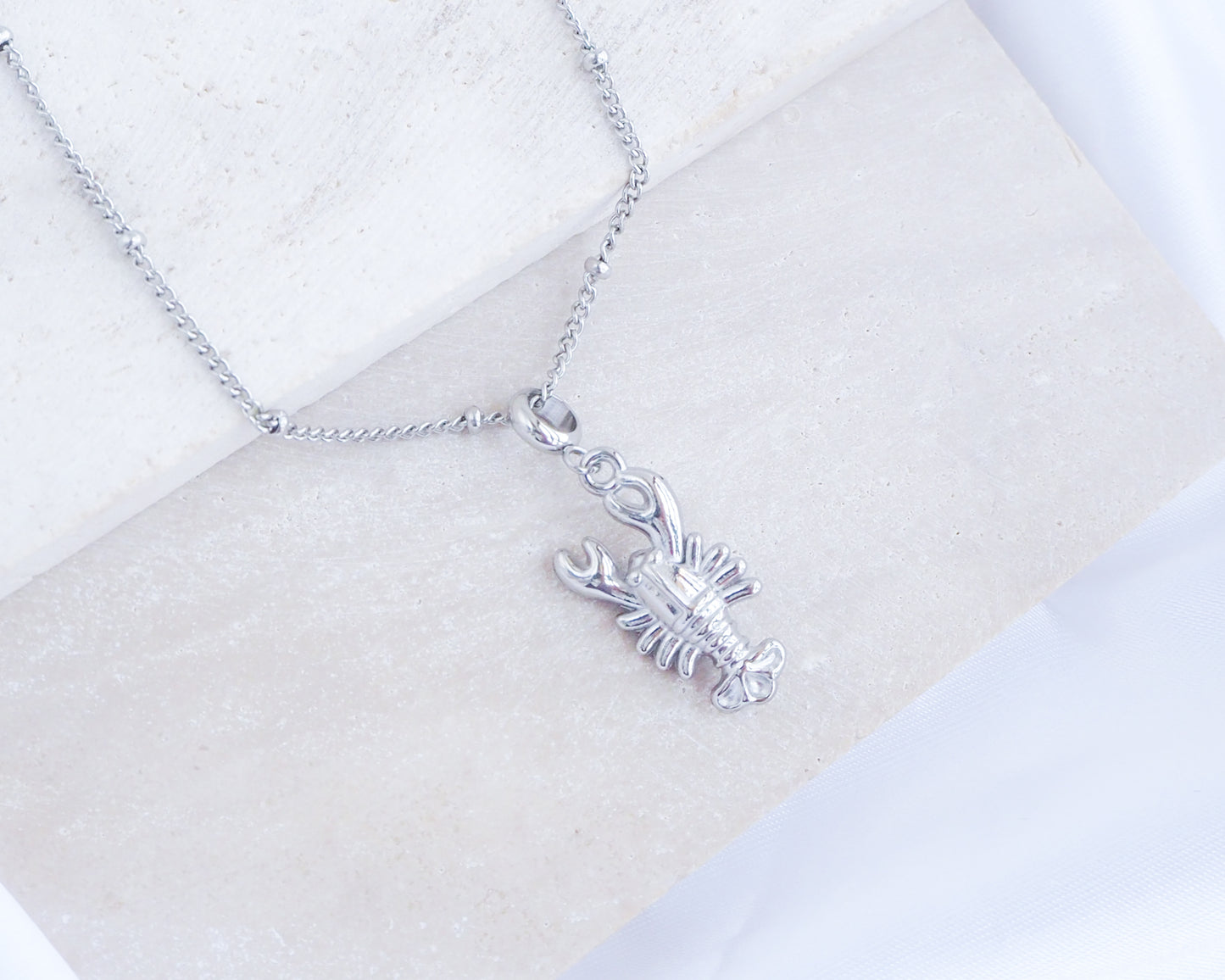 Silver Lobster Necklace on stone displayed, made with silver stainless steel, coastal jewelry from Portugal