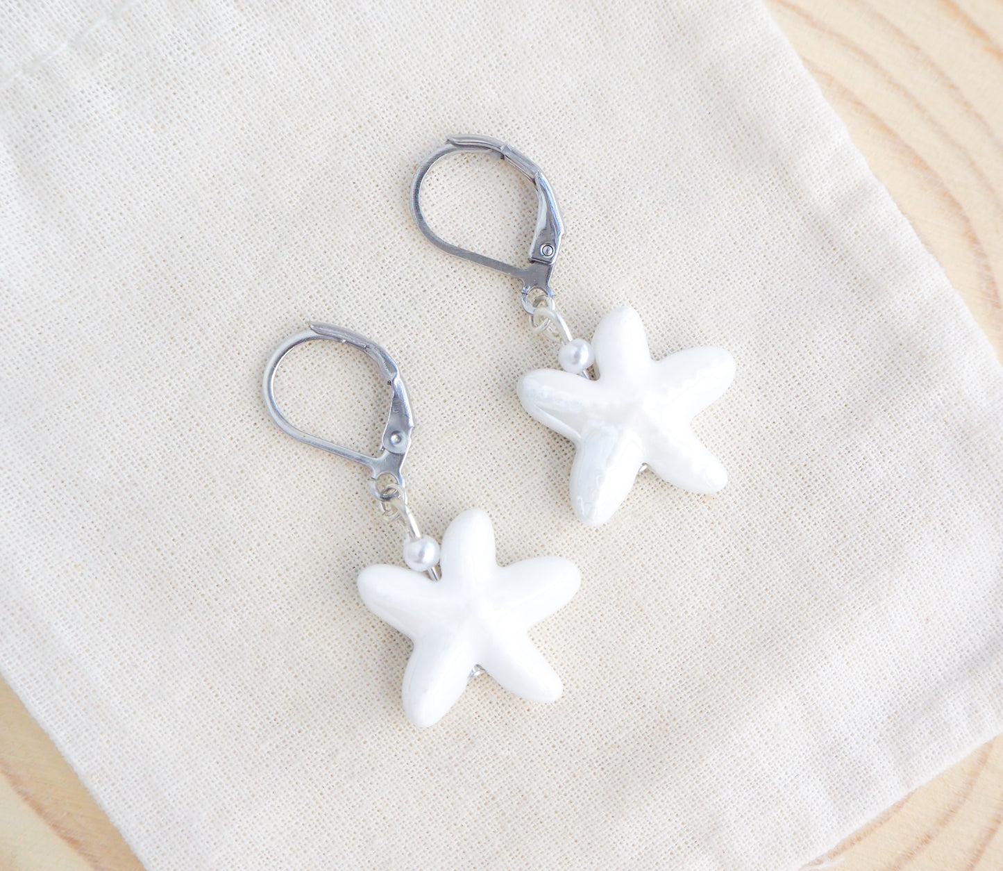 White Ceramic Starfish Sea Star Silver Earrings on display