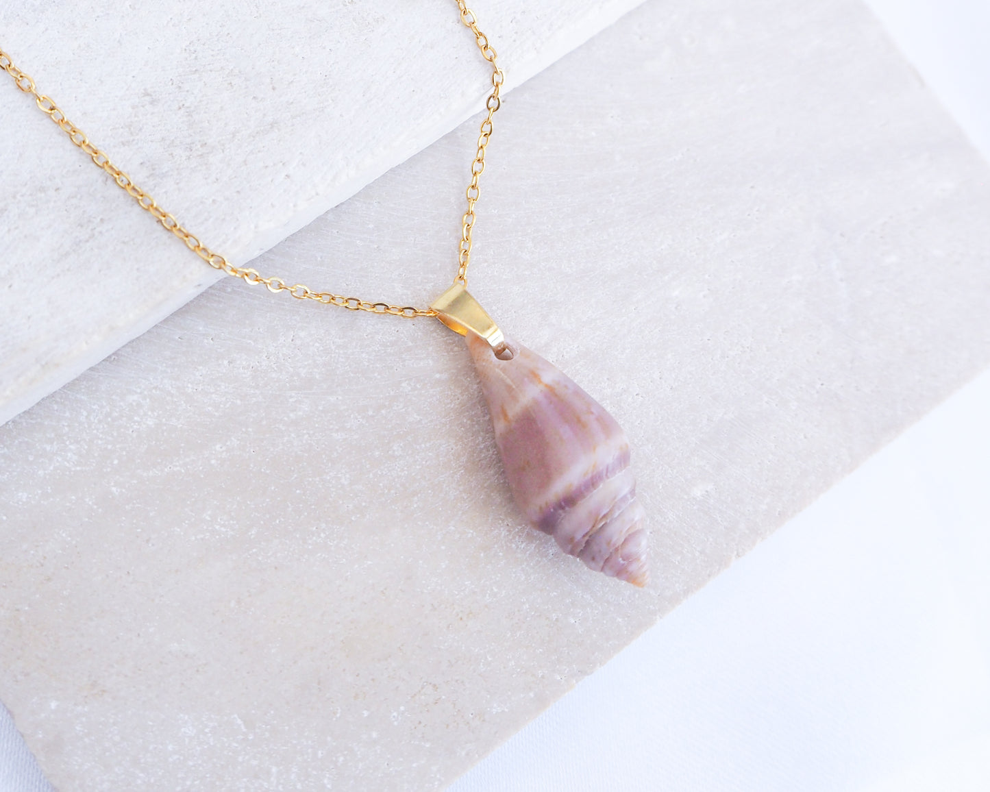 Slim Mediterranean Cone Shell Gold Necklace from Portugal displayed on stone