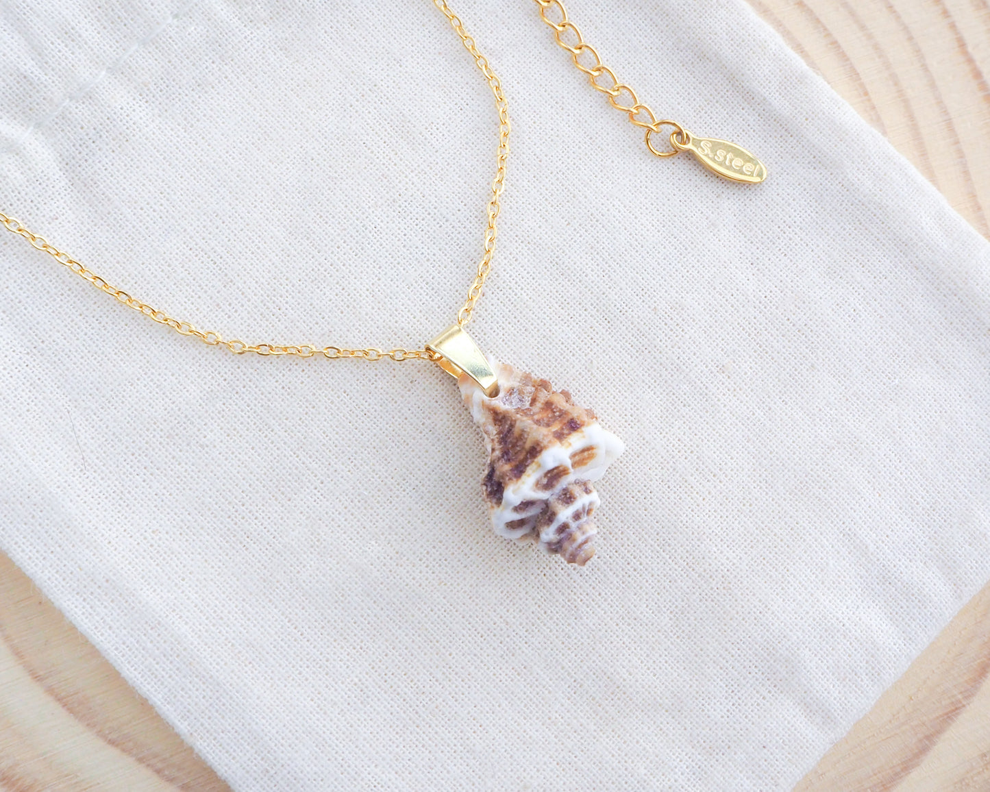 Brown Sting Winkle Gold Necklace on display