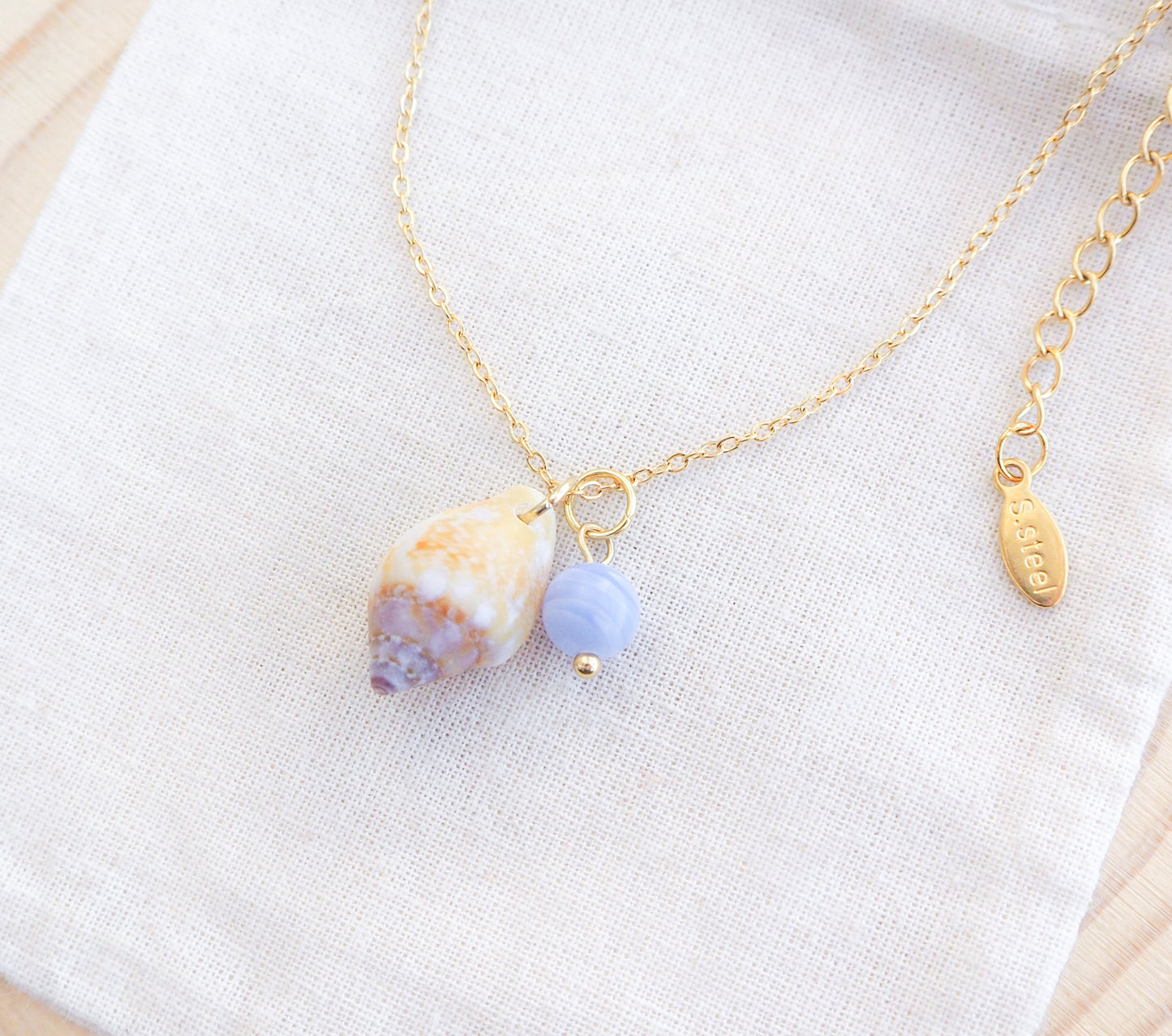 Tiny Light Rustic Dove with Angelite Gemstone Gold Necklace on display