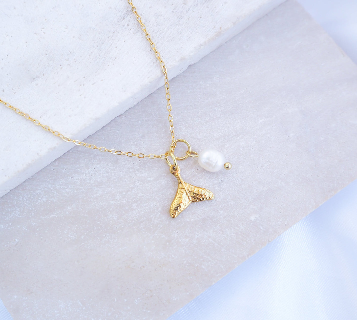 Dainty Gold Whale Tail Pearl Necklaces on stone with freshwater pearls and 18k gold whale pendant