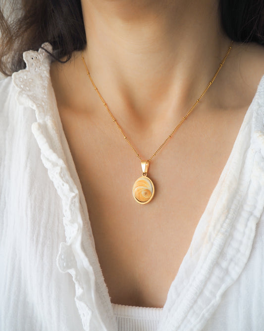Yellow Orange Eye of Saint Lucia Gold Necklace on neck model with white blouse and brown hair, 18k gold stainless steel shiva Yellow Orange eye pendant necklace, Saint Lucy Eye, operculum pendant