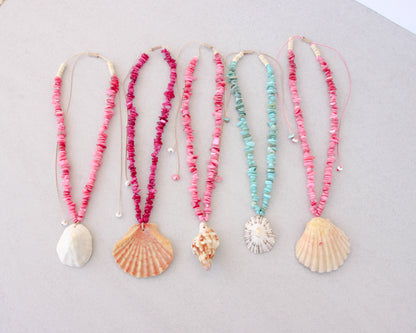 Five handmade shell bead necklaces with seashell pendants are arranged in a row on a light gray background. The necklaces feature pink, magenta, and turquoise beads with natural seashells as pendants. Portuguese shell necklaces all handpicked real big shells. 