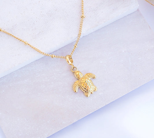 Gold Baby Turtle Necklace on stone, sea turtle necklace