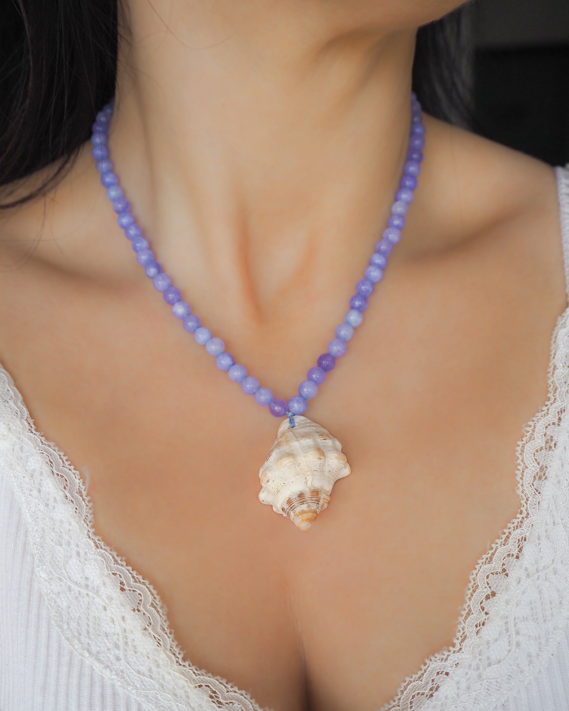 Model wearing Red-mouthed Dog Winkle Shell with Angelite Gemstone Necklace on neck, Blue gemstone bead necklace with off white big conch shell