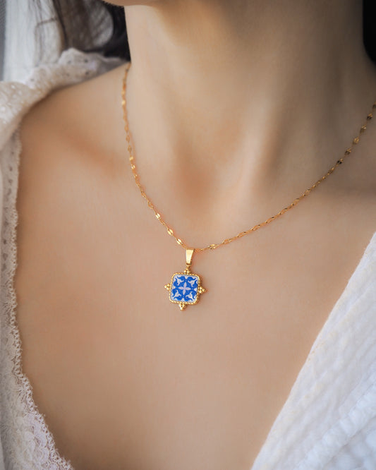 Model wearing Blue Portuguese Tile Square Necklaces on neck. Made with 18k gold stainless steel and white blue mosaic pendant inspired by the Portuguese Azulejo design pattern. 