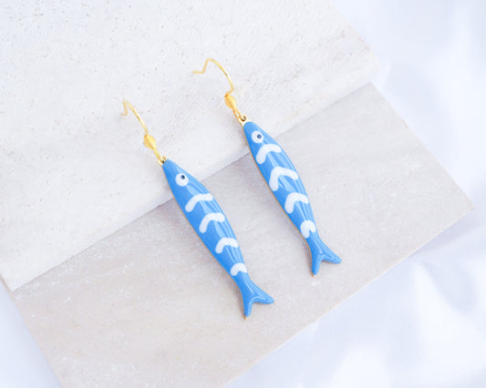 Blue Sardine Fish Earrings with 14k gold stainless steel earring hooks displayed on stone, Beautiful gift for Portugal lovers or holiday memory, coastal jewelry from Portugal
