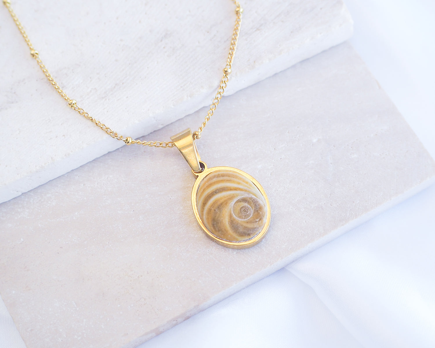 Brown Eye of Saint Lucia Gold Necklace on stone displayed, 18k gold stainless steel brown shiva eye pendant necklace, Saint Lucy Eye, operculum pendant