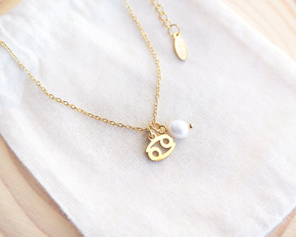 Gold Cancer Zodiac Pearl Necklace on display, made with 18k gold stainless steel and white freshwater pearl 