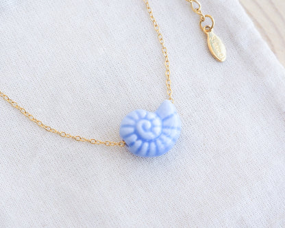 Blue Ceramic Seashell Nautilus Gold Necklace on display
