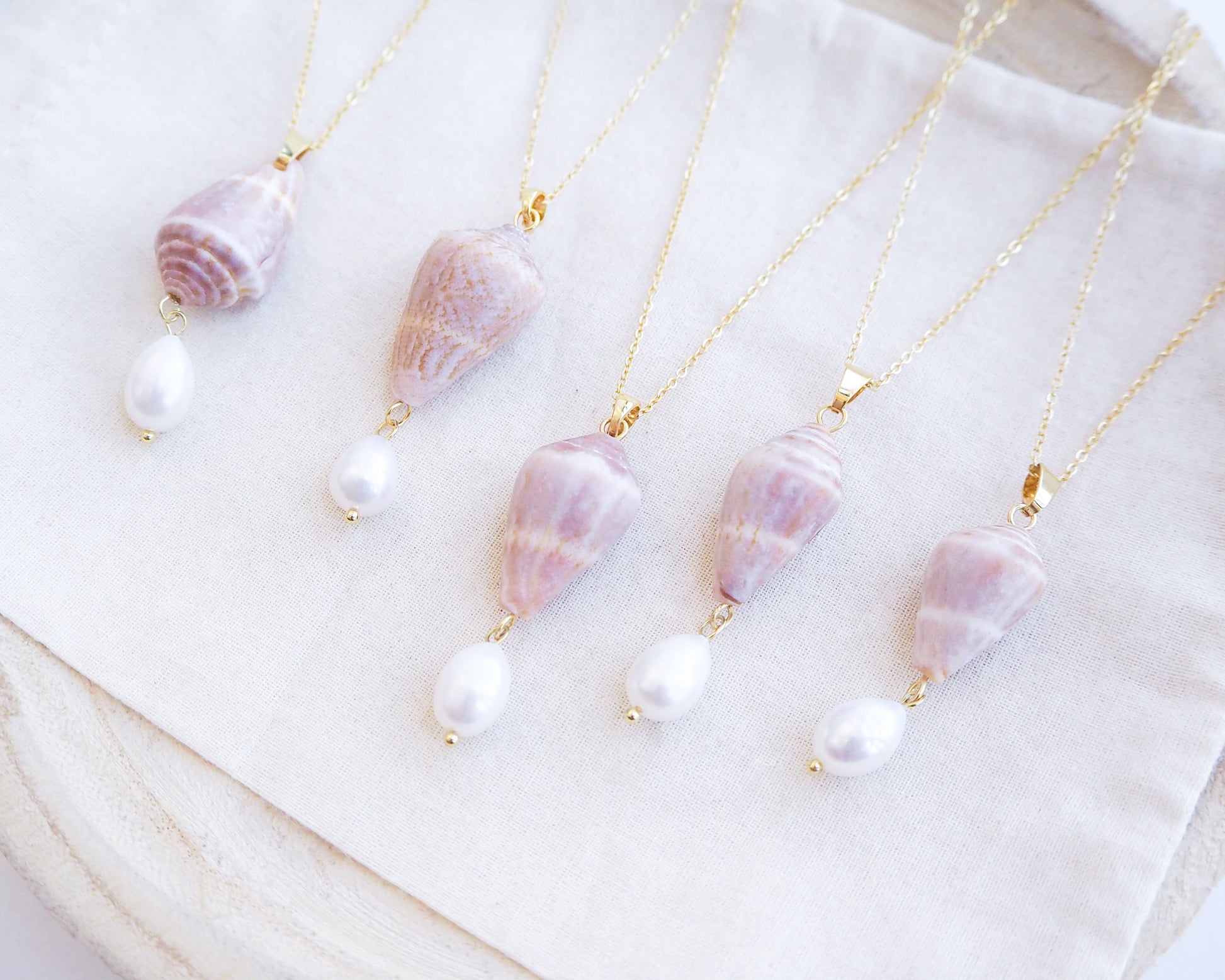 Side view of Mediterranean Cone Shell Pearl Necklace Reversed from Portugal displayed, handpicked cone shell from Algarve, Freshwater pearl and 18k gold stainless steel chain