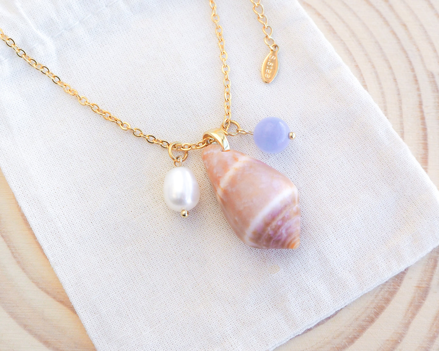Cone Shell Gemstone Pearl Trio Necklace on display with Cone Shell from Portugal