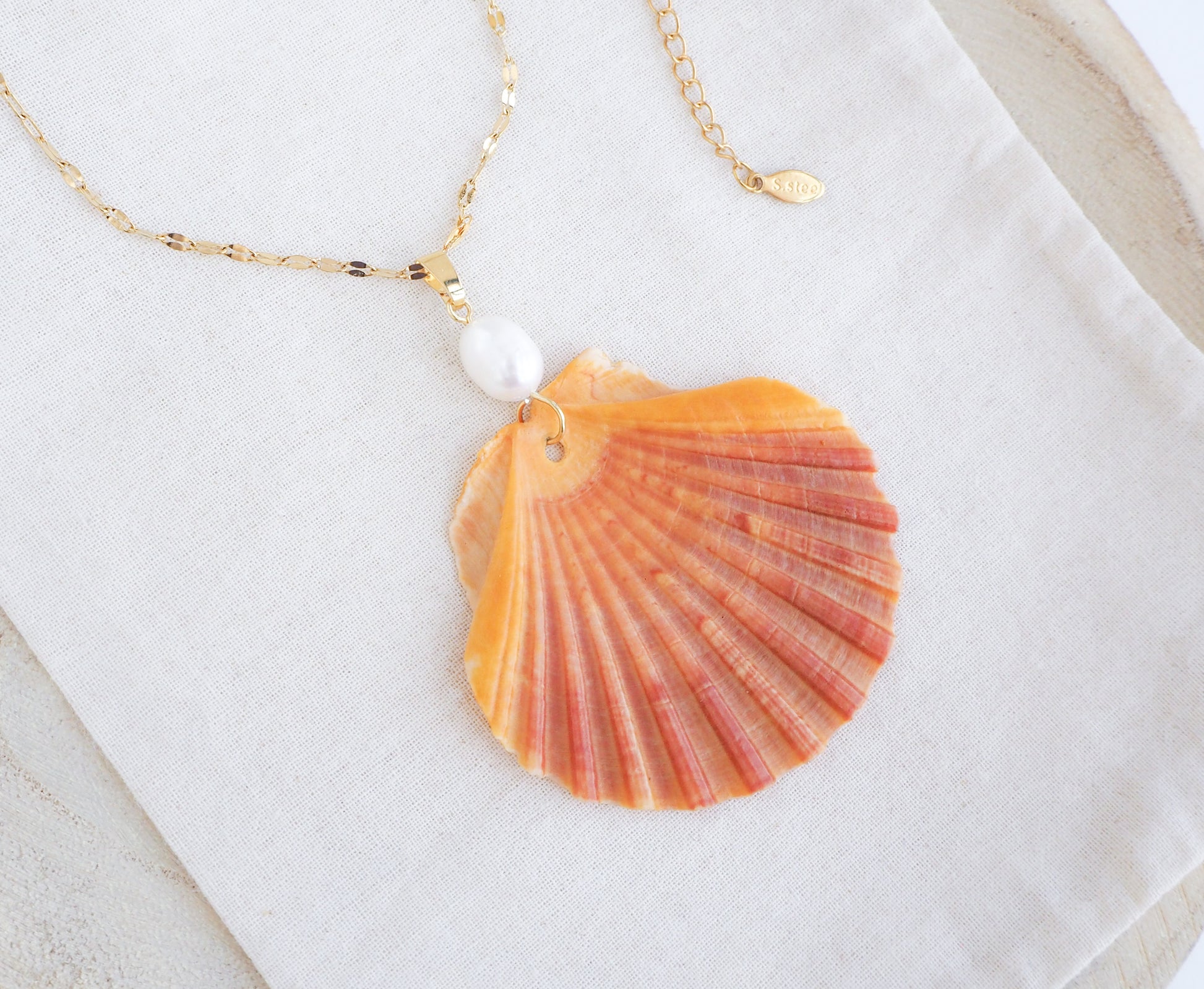 Coral Orange Scallop Shell Pearl Gold Necklace on display, Pilgrims Scallop Shell from Portugal with freshwater pearl and gold chain. 