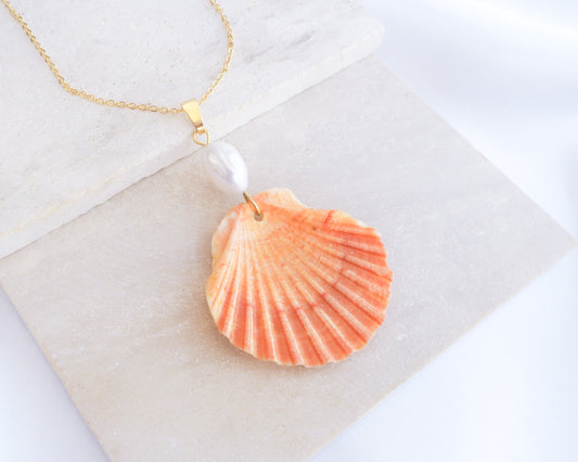 Coral Orange Scallop Shell Pearl Gold Necklace V on stone displayed, Pilgrims Scallop Shell from Portugal with freshwater pearl and gold chain. 