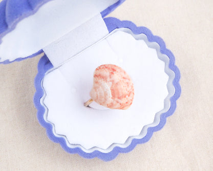 Close up of Coral Pink Venus Shell Ring displayed in seashell jewelry box, Marble Pink shell on gold ring, handpicked real shell from Portugal