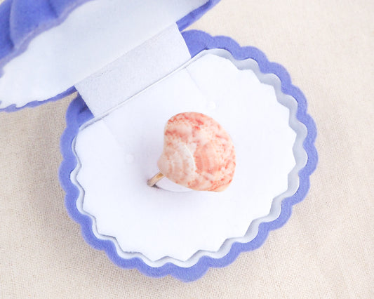 Close up of Coral Pink Venus Shell Ring displayed in seashell jewelry box, Marble Pink shell on gold ring, handpicked real shell from Portugal