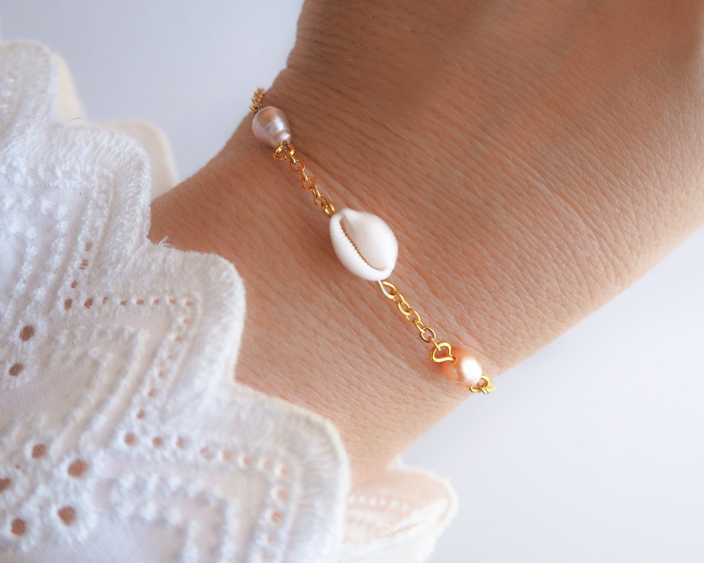 European Cowrie Shell and Freshwater Pearl Gold Bracelet on wrist, tiny cowrie shell from Portugal