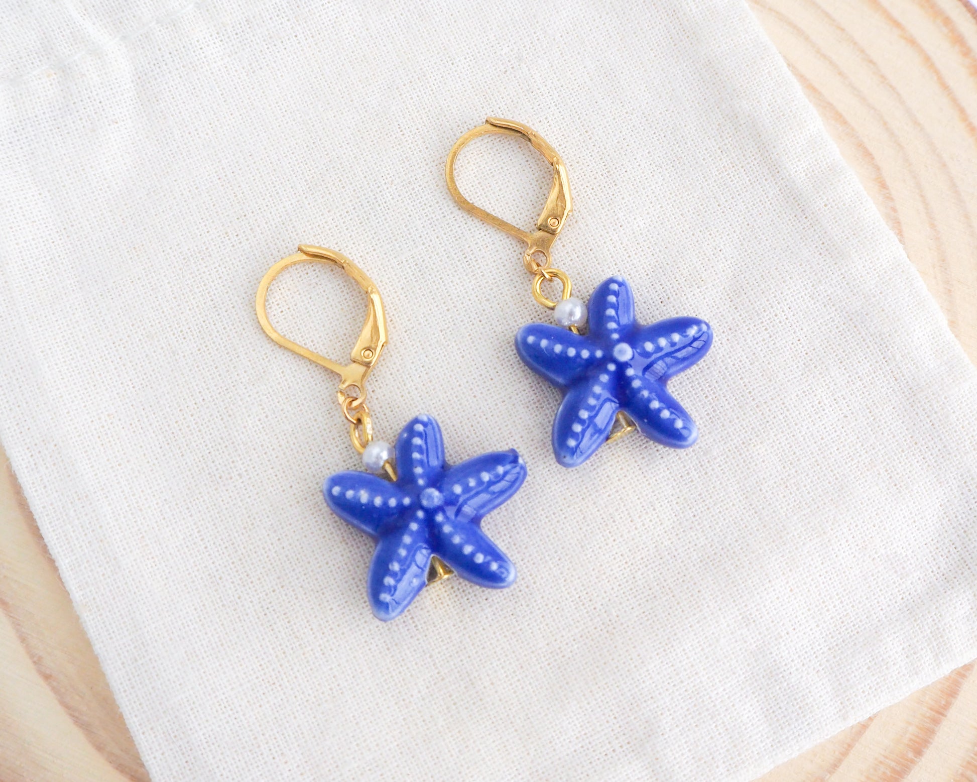 Dark Blue Starfish Ceramic Earrings on display