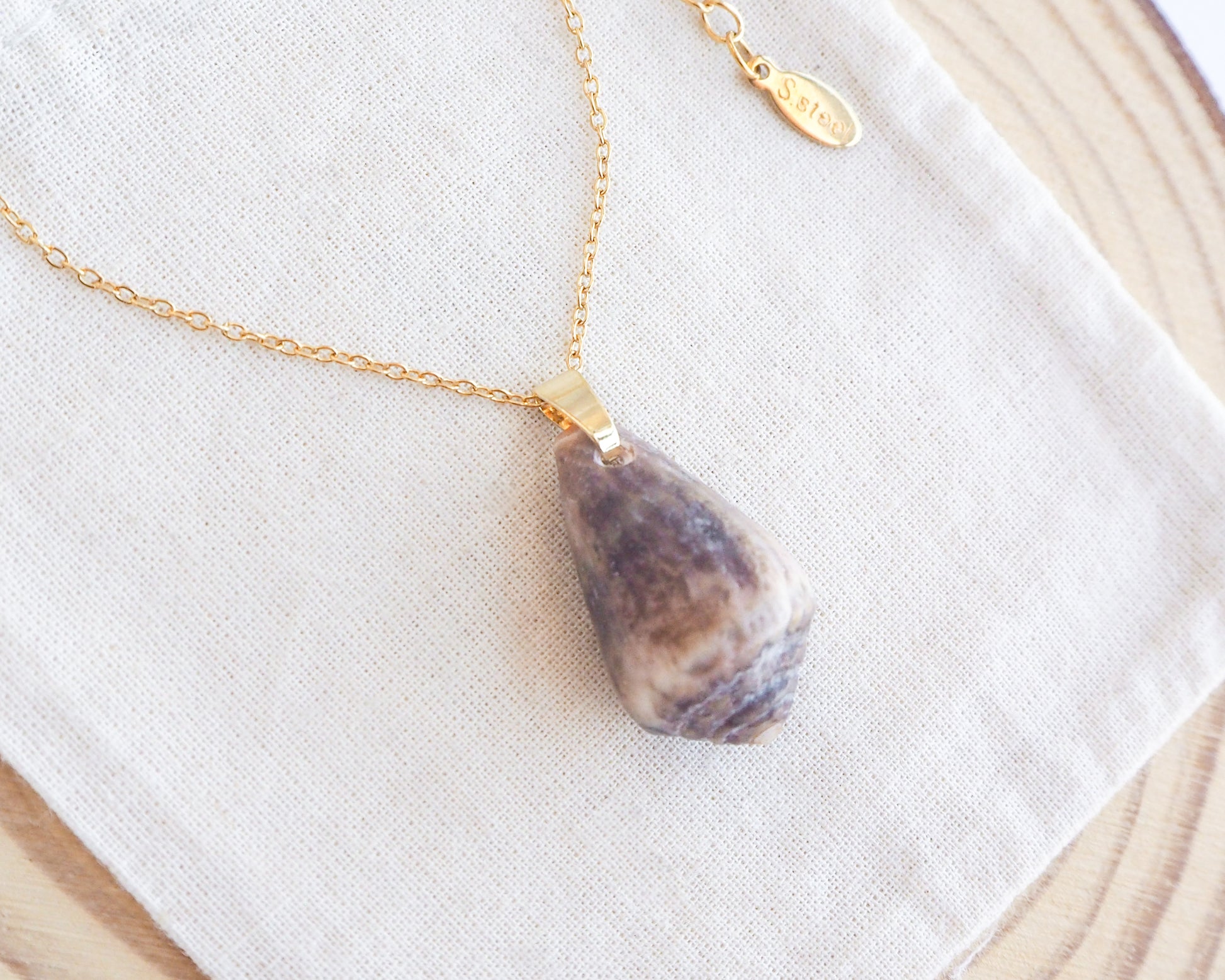 Dark Mediterranean Cone Shell II Gold Necklace on display