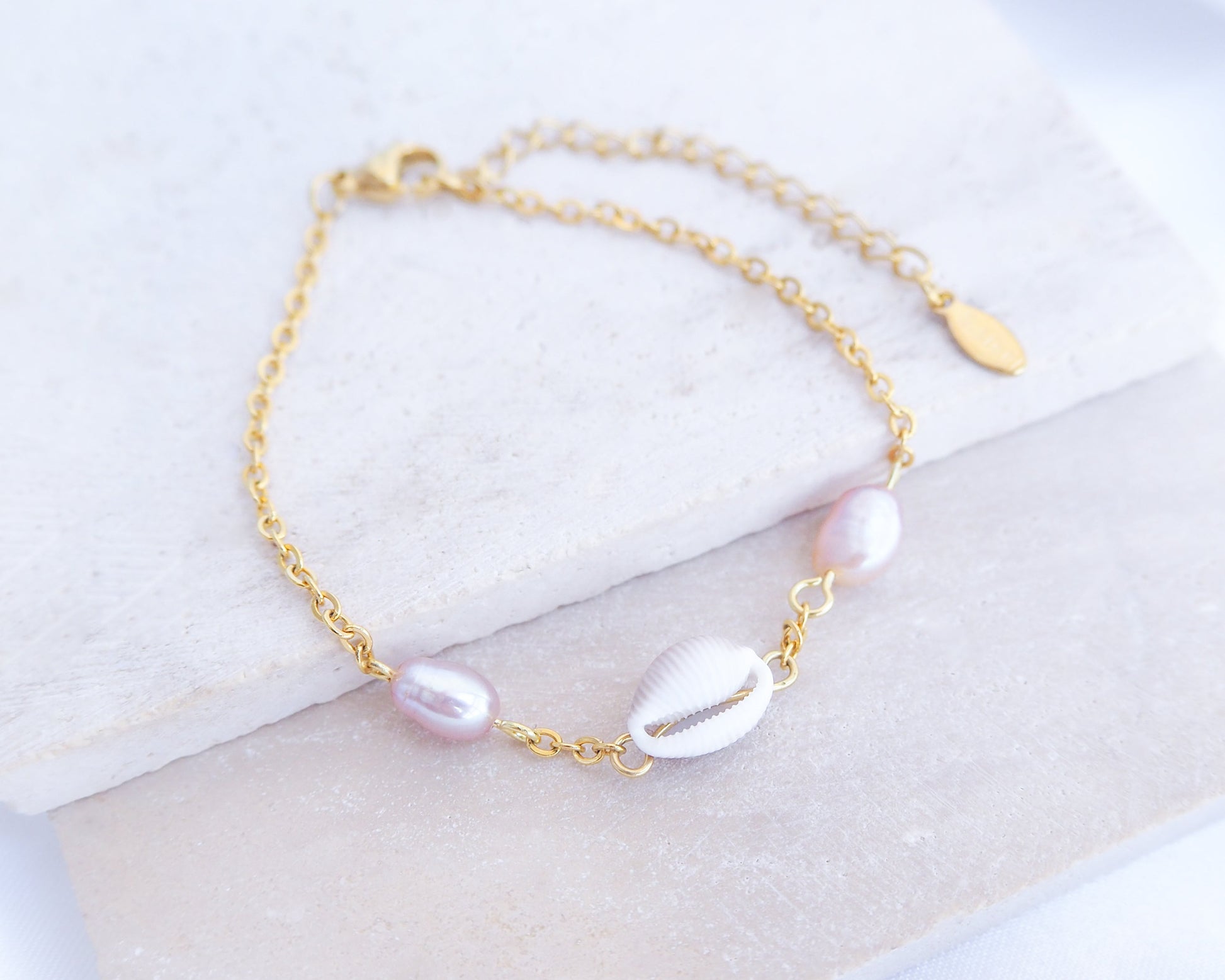 European Cowrie Shell and Freshwater Pearl Gold Bracelet on stone displayed, tiny cowrie shell pearl bracelet with handpicked cowrie shell from Portugal