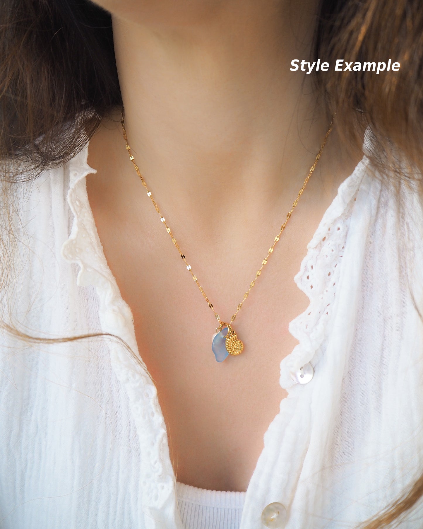 Example photo of model wearing Oceanic Trio Nautilus Blue Sea Glass Pearl Necklace on neck, nautilus shell necklace, ocean blue necklace, coastal jewelry, freshwater pearl necklace, gold seashell necklace, ocean-inspired jewelry, beach necklace, ocean treasure necklace