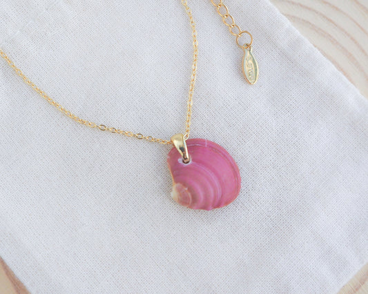 Fuchsia Plum Venus Shell Necklace on display, made with 18k gold stainless steel and a handpicked venus shell from Portugal. 