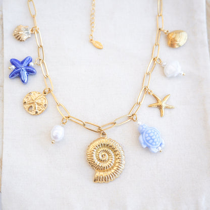Front view of Blue Ocean Ceramic Charm Necklace with 3 blue ceramic charms (turtle, starfish, shell), Shell pendant, sand dollar pendant, starfish pendant, 18k gold stainless steel chain  