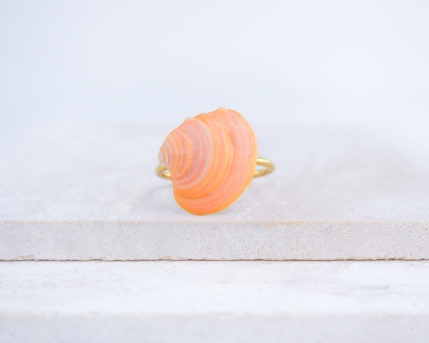 Coral Orange Shell Ring from Portugal displayed on stone, colorful orange shell gold ring