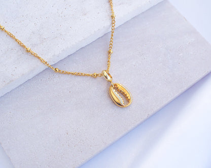 Gold Cowrie Necklace on stone 
