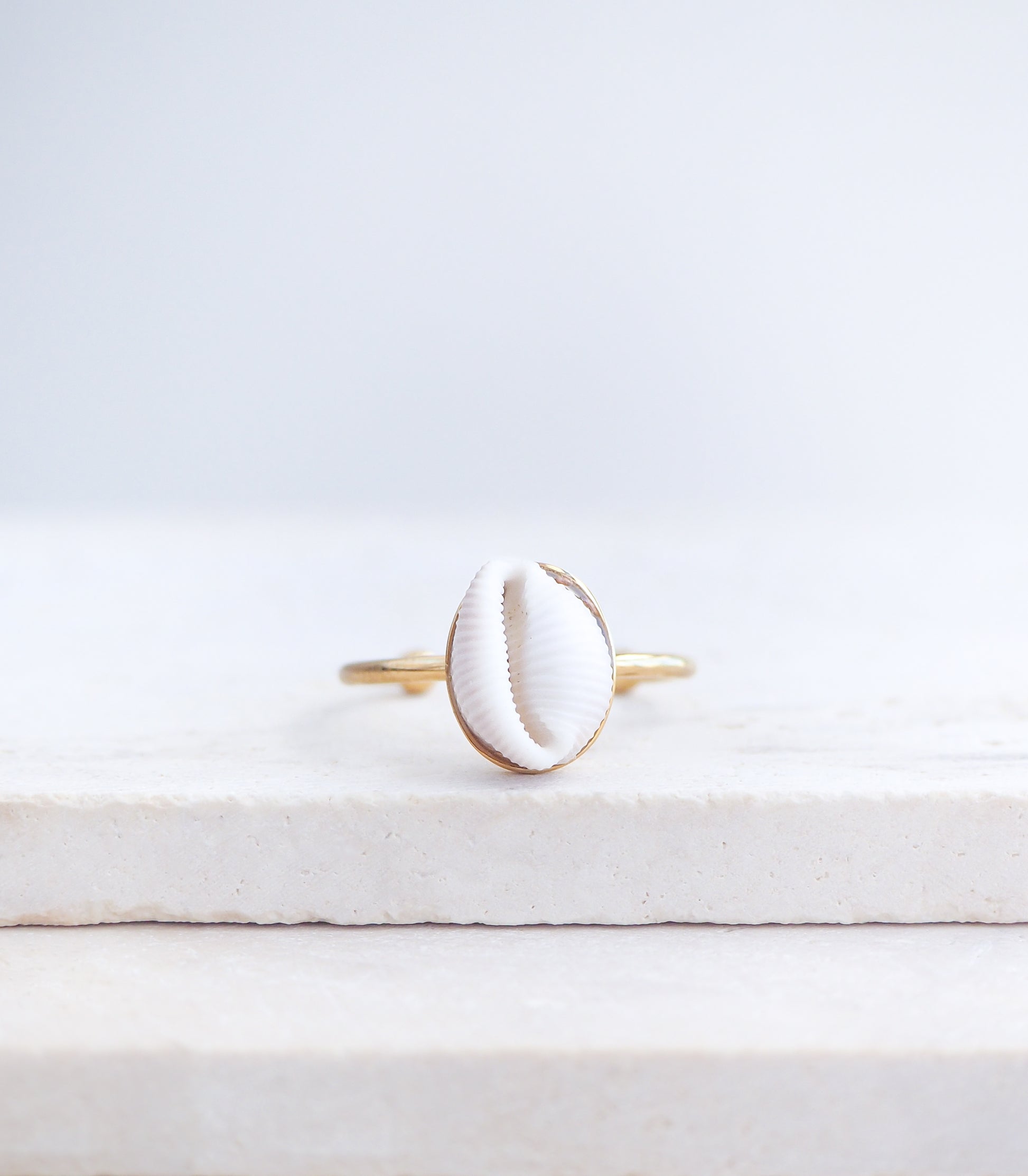 Close up front view of European Cowrie Shell Gold Ring from Portugal on stone display, Handpicked Spotted Cowrie Shell from Portugal, Gold Stainless Steel ring with tiny cowrie shell, Gift for beach girls