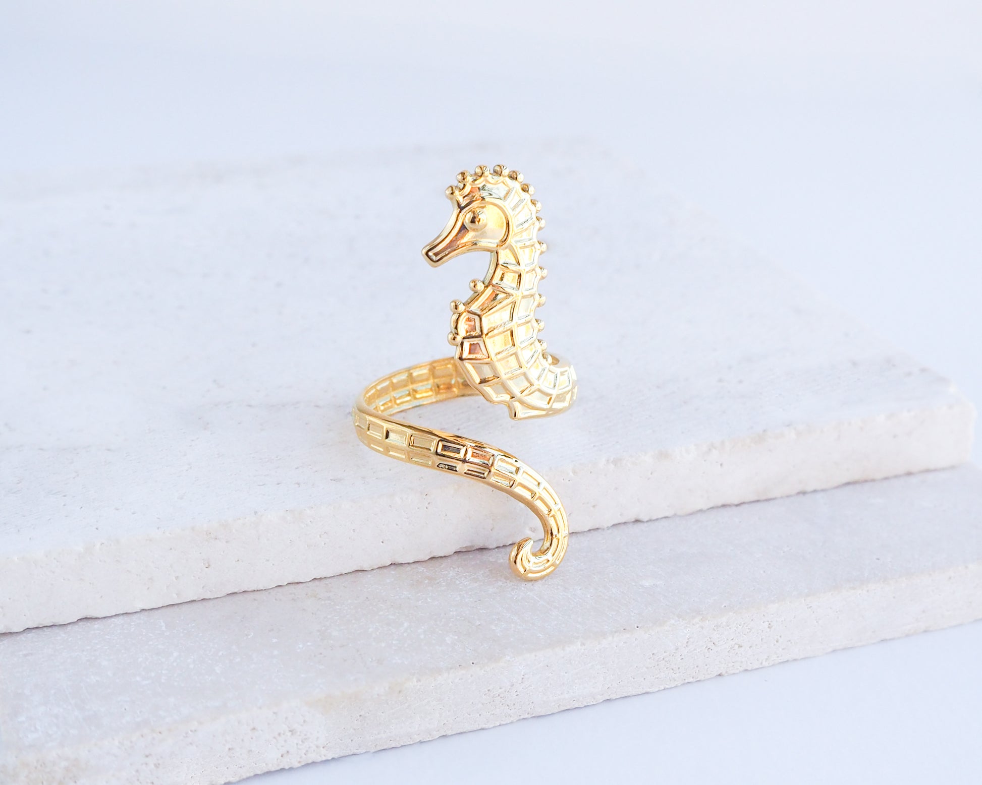 Gold seahorse ring on stone background, hippocampus ring 14k gold stainless steel