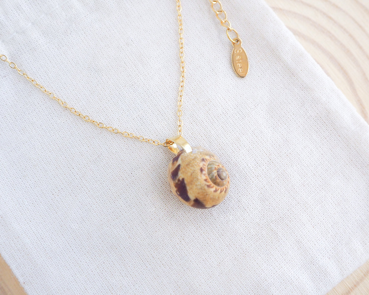 Side view of Moon Shell Gold Necklace on display. Handpicked shell from Portugal with 18k gold stainless steel chain