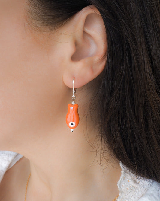 Orange Ceramic Fish Gold Earrings in ear model