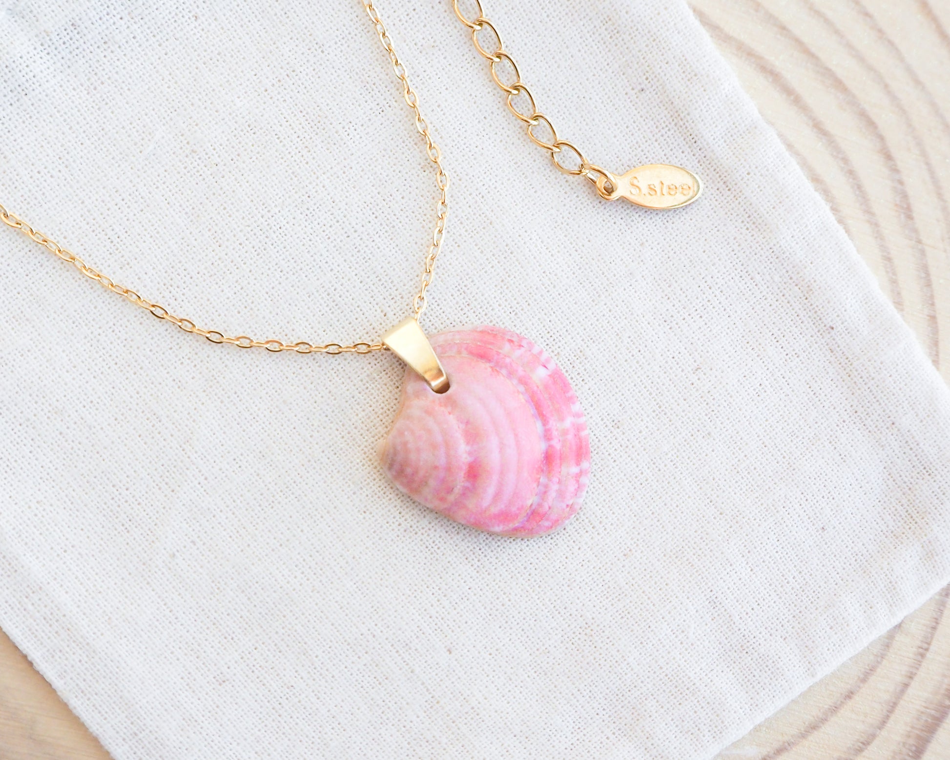 Gold Pink Venus Shell Necklace on cotton displayed. Pink Shell from Portugal. Necklace made with 18k gold stainless steel