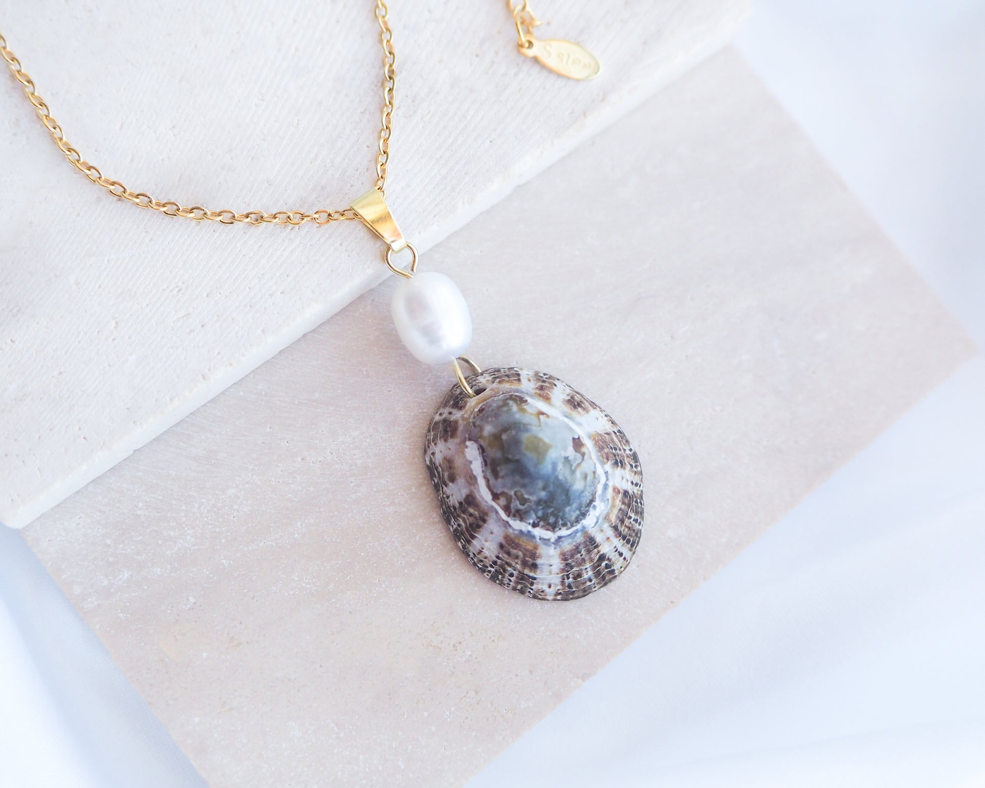 Front view of Rustic Limpet Shell Pearl Necklace on display, Blue White Striped Limpet Shell from Portugal with freshwater pearl and gold chain. 