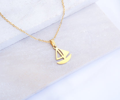 Gold Sailing Boat Necklace made with 14k gold stainless steel on display