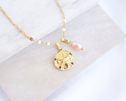 Gold Sand Dollar Rose Freshwater Pearl Deluxe Necklace on display, close up of 18k gold Sand Dollar Pendant with deluxe chain 