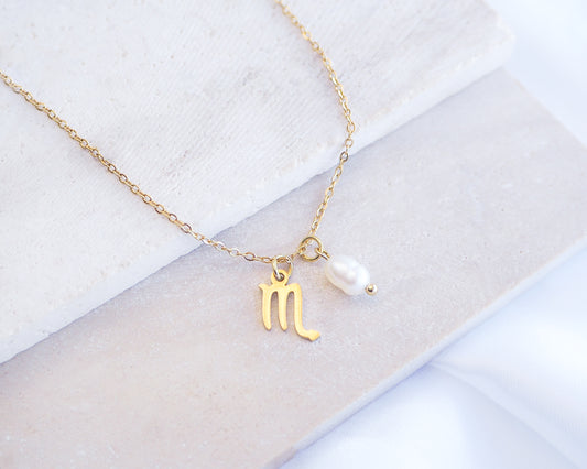 Gold Scorpio Zodiac Pearl Necklace on stone displayed, made with 18k gold stainless steel and white freshwater pearl 